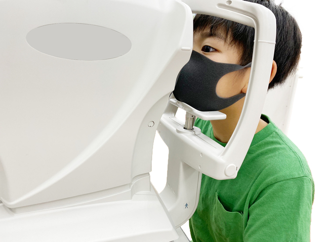 眼科で目の検査を受ける子供