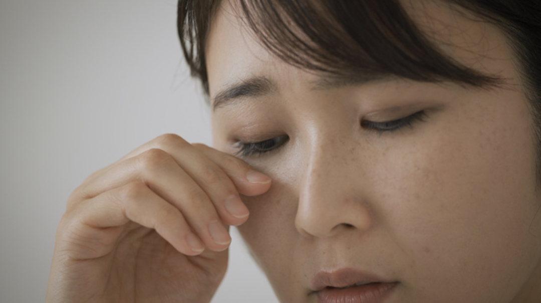 目を擦る女性