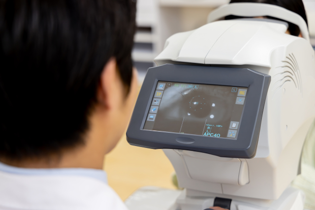 眼科医が検査機器で眼底を確認している様子